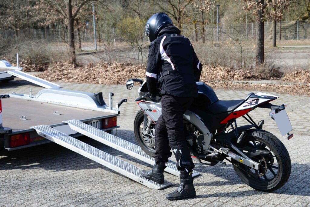 Motorrad Tandem Anhänger Motorradfahrer schiebt sein Bike hoch