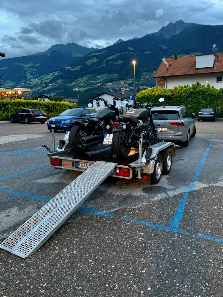 Motorrad Tandem Anhänger beladen mit 2 Motorrädern und Auffahrschiene vor Bergen